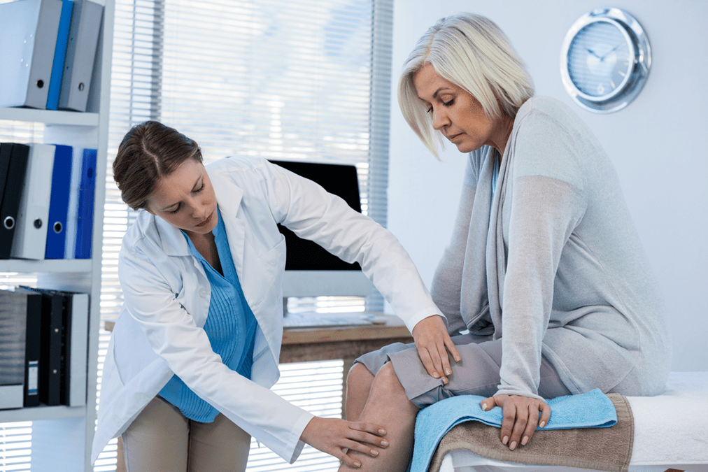 Een patiënt met artrose die therapie nodig heeft, wordt door een arts onderzocht